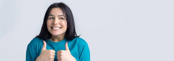 青いTシャツに身を包んだ幸せな若い白人女性が親指を立てて微笑む 良い仕事と尊敬 — ストック写真