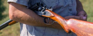 Sazlıklarda güneşe karşı silahlı bir avcının silueti. Köpekli ördekler için bir pusu.