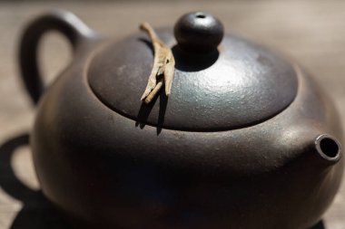 Çin çay seremonisi. Balçıktan yapılmış seramik çaydanlık ve ahşap bir arka planda kaseler.