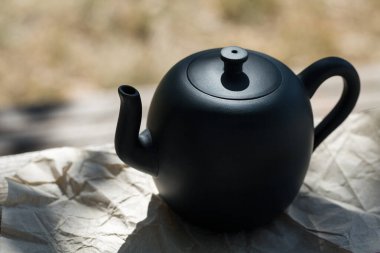 Çin çay seremonisi. Balçıktan yapılmış seramik çaydanlık ve ahşap bir arka planda kaseler.