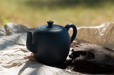 Çin çay seremonisi. Balçıktan yapılmış seramik çaydanlık ve ahşap bir arka planda kaseler.