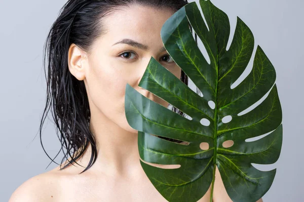 Beauty Woman with natural green palm leaf portrait. Fashion, beauty, make-up, cosmetics.