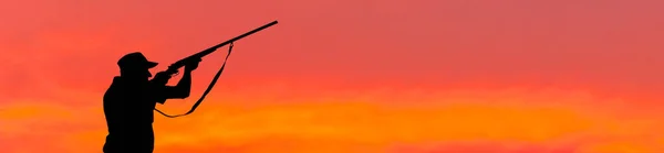 Sazlıklarda Güneşe Karşı Silahlı Bir Avcının Silueti — Stok fotoğraf