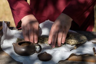 Çin çay seremonisi. Balçıktan yapılmış seramik çaydanlık ve ahşap bir arka planda kaseler.