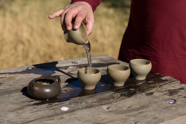 Китайская чайная церемония. Керамический чайник из глины и миски на деревянном фоне.