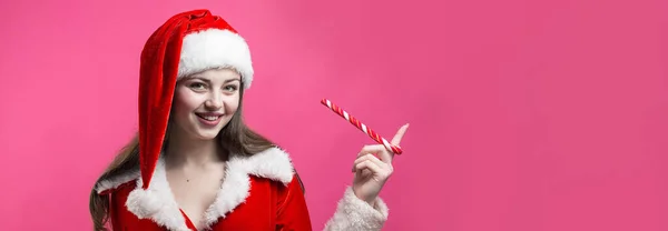 穿着圣诞老人服装的年轻貌美的女人衬托着红色的背景 — 图库照片