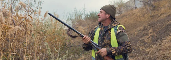 狩猎季节期间带着猎枪和背包在农村田里打猎的人 — 图库照片