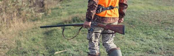狩猟シーズン中に散弾銃とバックパックを持つ農村部のフィールドでハンター男 — ストック写真