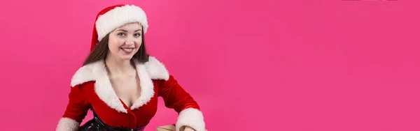 穿着圣诞老人服装的年轻貌美的女人衬托着红色的背景 — 图库照片