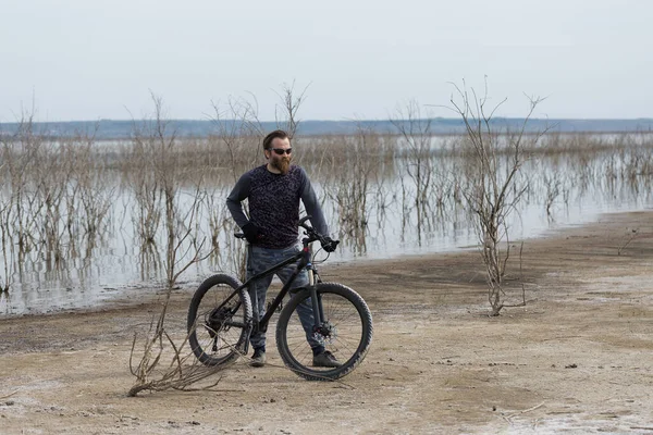 現代のマウンテンバイクで残酷な髭の男をスポーツ 湖に捨てられた塩の中のサイクリスト — ストック写真