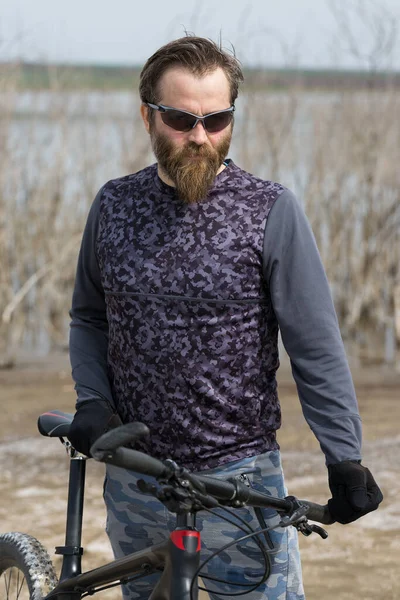 現代のマウンテンバイクで残酷な髭の男をスポーツ 湖に捨てられた塩の中のサイクリスト — ストック写真