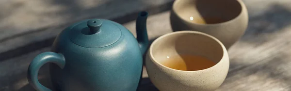 Chinese tea ceremony. Ceramic teapot made of clay and bowls on a wooden background.