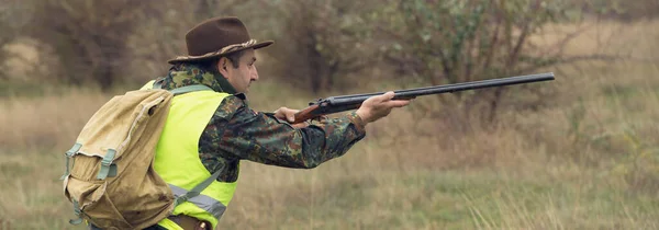 アヒルハンターで散弾銃を持った牧草地を歩く — ストック写真