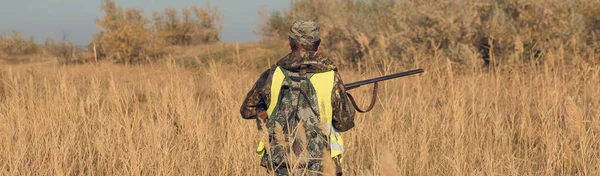 带着猎枪在草地上行走的猎鸭者 — 图库照片