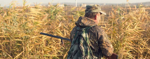 アヒルハンターで散弾銃を持った牧草地を歩く — ストック写真