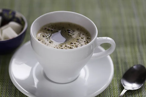 beyaz kahve fincanı, çay kaşığı ve şeker bir tablo