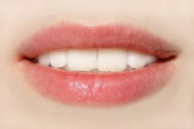 A pretty woman's mouth with beautiful, well-groomed white teeth clipart