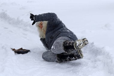 Tehlikeli kaygan yollar ve kaldırımlar kışın. Bir kadın bir karlı yolda kayıp gidiyor. 