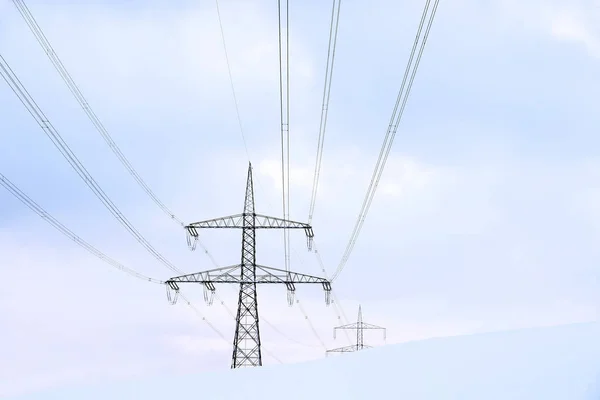 Overhead line with power cables in winter. Power poles in winter