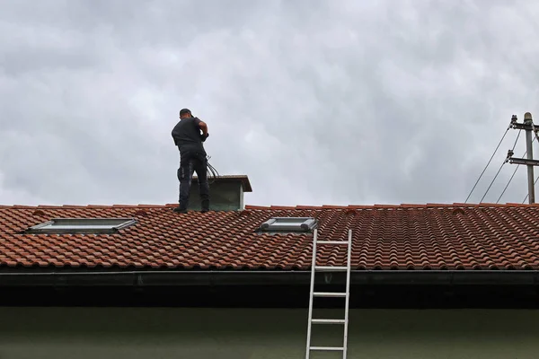 Ein Schornsteinfeger Auf Dem Dach Reinigt Einen Schornstein Mit Einer — Stockfoto