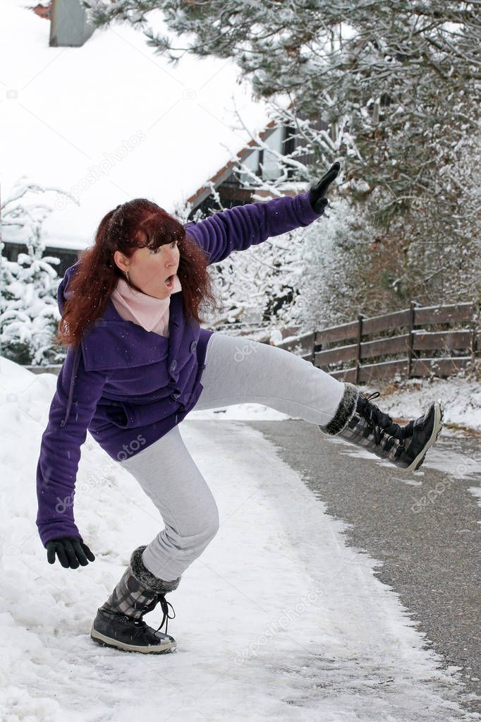 Dangerously slippery roads and sidewalks in winter. A woman slips on a snowy road 