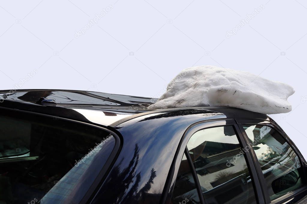 A roof avalanche damaged a black car on the roof. Avalanche of roof damage to a car