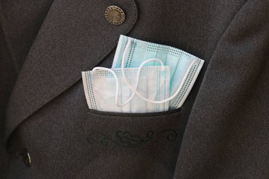 Bir takım elbiseli iki korona maskesi var. Günlük hayatta koruyucu maskeler