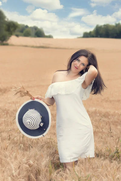 晴れた日に麦畑で休む若い女性 — ストック写真