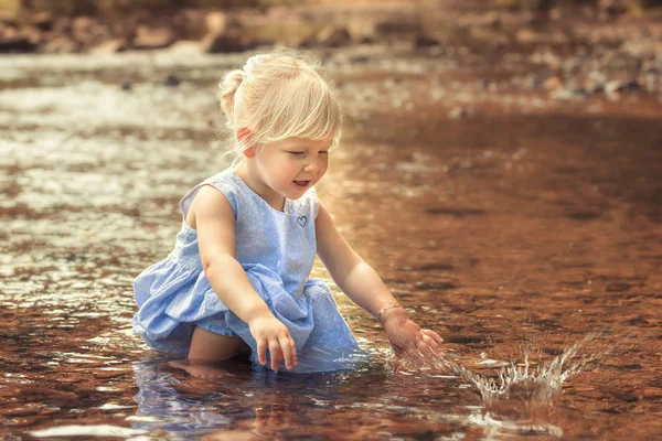 小さな女の子は 川の水で遊んでください — ストック写真