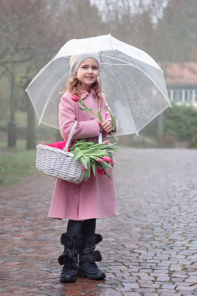 在雨天带着一束郁金香的女孩 — 图库照片