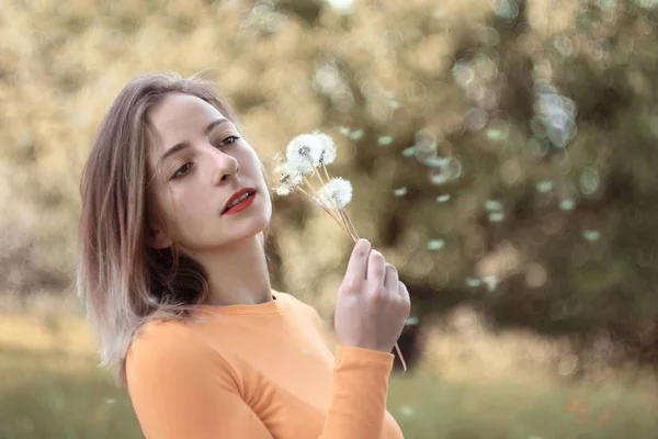 Portret van een jonge vrouw met paardebloemen — Stockfoto