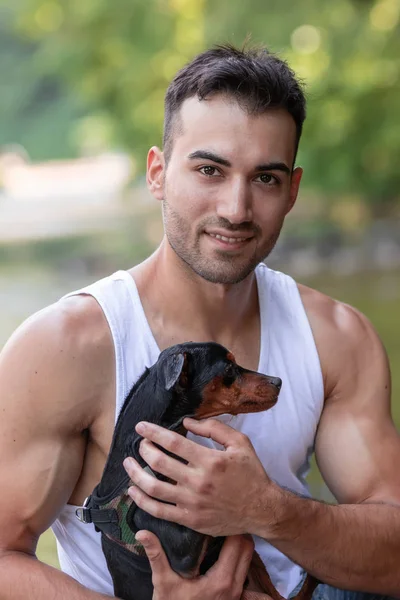 Close-up retrato de belo jovem com cão, ao ar livre . — Fotografia de Stock