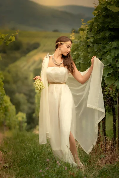 Giovane donna in tunica vendemmia uva — Foto Stock