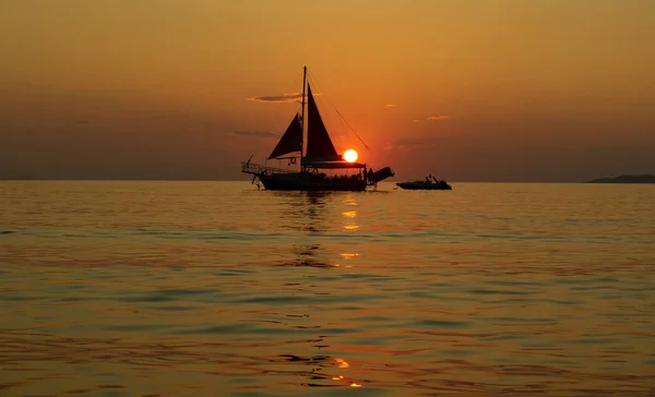 Plachetnice na moři při západu slunce — Stock fotografie