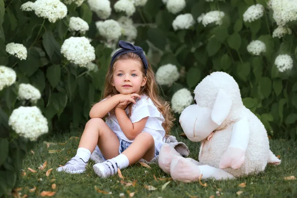 Klein Meisje Met Speelgoed Witte Bloemen — Stockfoto