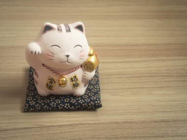 Ahşap arka plan üzerinde şanslı kedi.