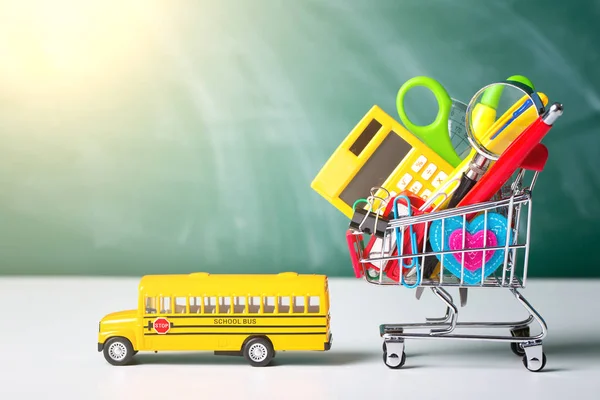 Geri okul kavramı. Okul malzemeleri, lokomotif ve malzeme ile alışveriş sepeti