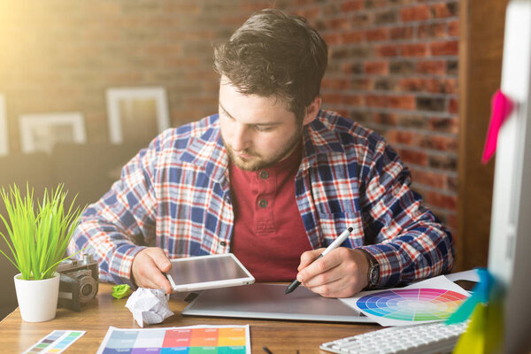 Молодой перспективный дизайнер с графическим планшетом в современном офисе
