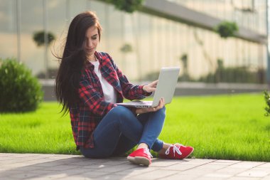 Açık havada çalışan genç esmer kadın öğrenci