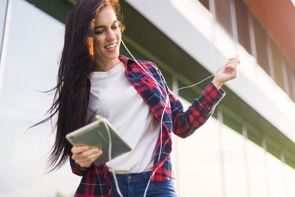 young brunette woman listen top chart song. Jump and dance on the grass