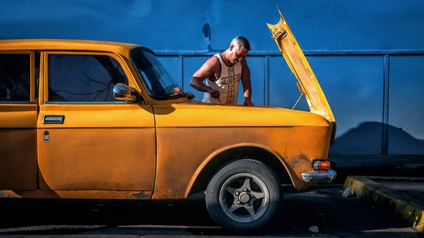 Drivrutinen fixar hans Moskvitch 2140 på en bensinstation nära Aguada de Pasajeros, Cienfuegos, Kuba — Stockfoto