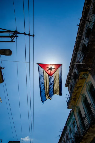 Bandera cubana cuelga en una calle del barrio obrero del centro de La Habana —  Fotos de Stock