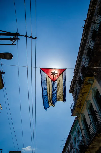 Bandeira cubana pendura em uma rua do bairro da classe trabalhadora de Central Havana — Fotografia de Stock