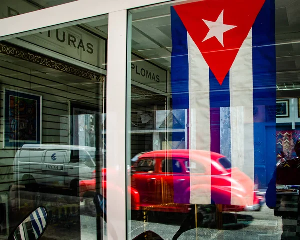 Κόκκινο αμερικανικό αυτοκίνητο και Κουβανέζικη σημαία, Αβάνα — Φωτογραφία Αρχείου