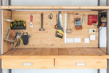 Wooden workbench at workshop. Lot of different tools for diy and repair works. Wood desk for product placement. Copyspace. Labour day clipart