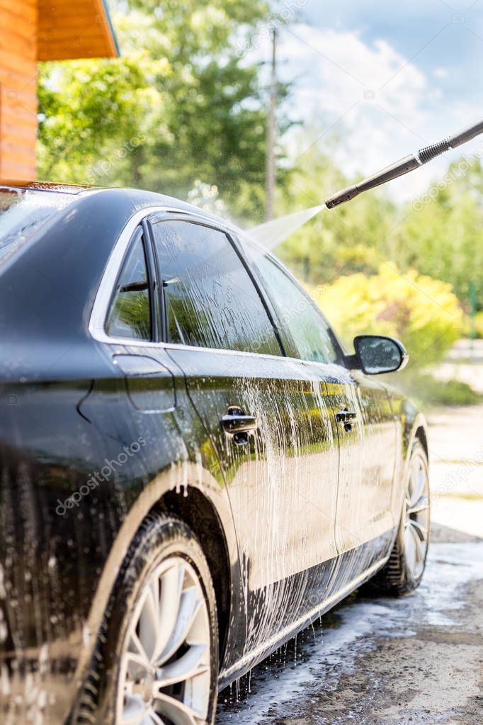 Manual car wash. Washing luxury vehicle with high pressure water pump.Automobile  cleaning self service