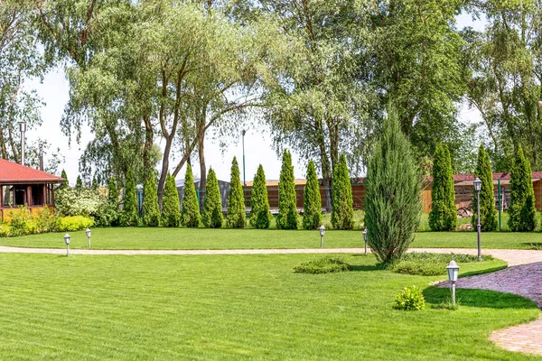 Fileiras recém-cortadas de gramado verde na residência de campo com casa de verão. Sebe de cedros frescos. Projeto da paisagem e conceito de jardinagem — Fotografia de Stock