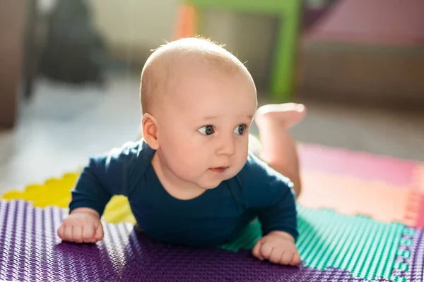 유아 아기 소년 컬러풀 소프트 매트에. 작은 아이 바닥에서 첫 번째 크롤링 단계 만들기. 위에서 상위 뷰 — 스톡 사진