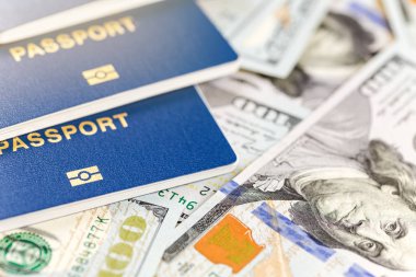 Üç biometrical uluslararası pasaport para arka plan üzerinde. Mavi seyahat belgeleri bize yüz dolarlık banknot yalan. Aile Turizm ve seyahat yurtdışında kavramı.