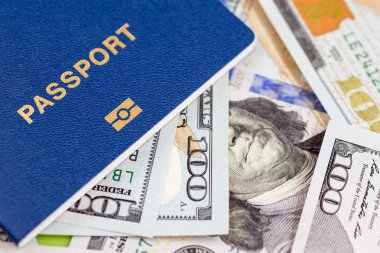Biometrical uluslararası pasaport para arka plan üzerinde. Mavi seyahat belgeleri bize yüz dolarlık banknot yalan. Turizm ve seyahat yurtdışında kavramı.